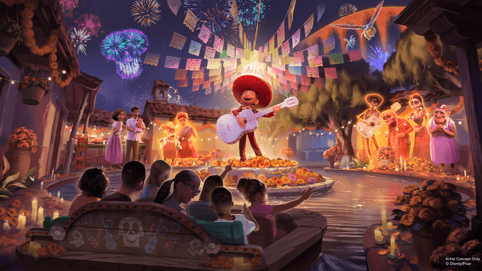 Colorful Coco celebration on a canal with musicians, banners, and fireworks at night at Disneyland