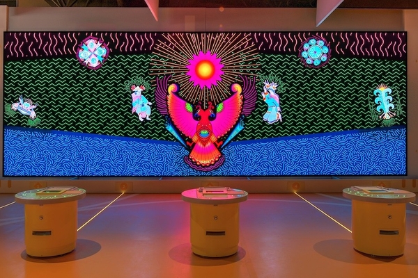 Colorful digital mural with abstract patterns and mystical creatures on a screen display.