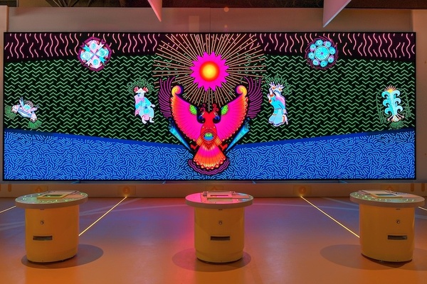 Colorful digital mural with abstract patterns and mystical creatures on a screen display.