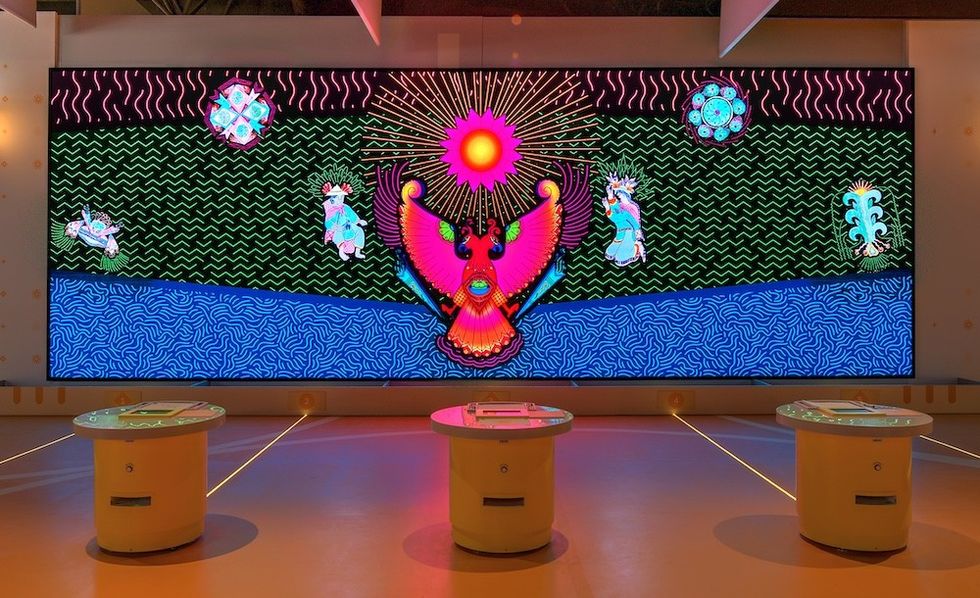 Colorful digital mural with abstract patterns and mystical creatures on a screen display.