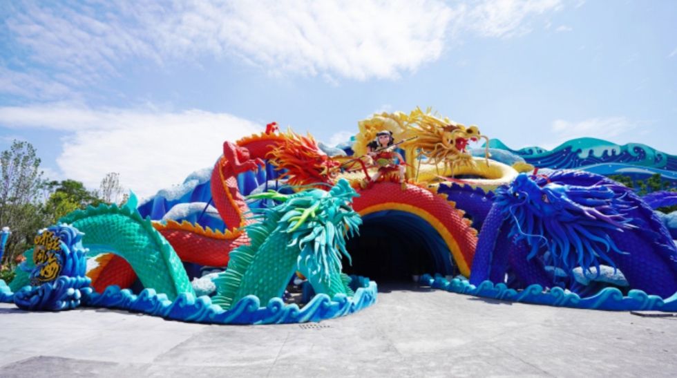 Colorful dragon sculptures adorn a tunnel entrance under a blue sky at mianyang fantawild oriental heritage
