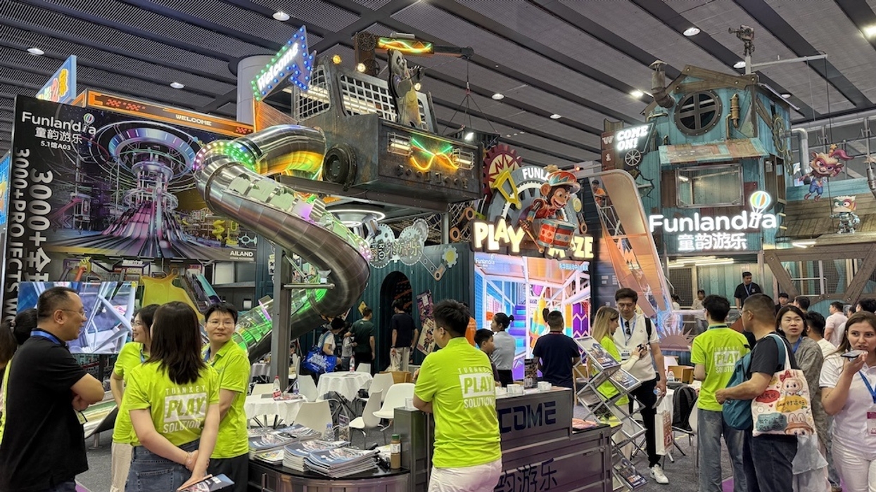 Colorful exhibition booth from Funlandia showcasing PlayMaze with slides and signs