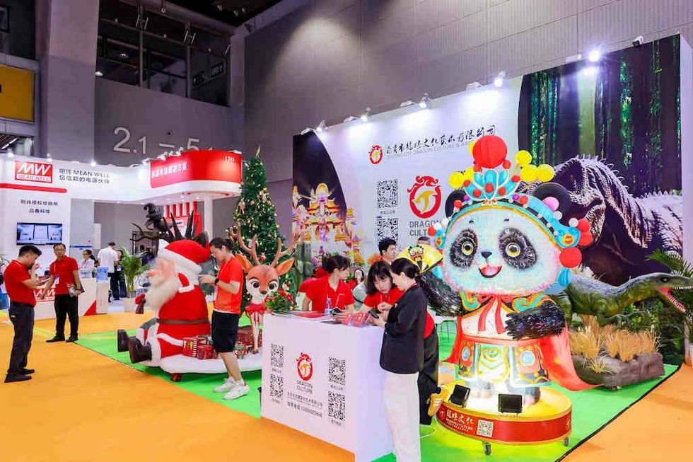 Colorful expo booth at GTI China Expo with Christmas decor, panda costume, and people interacting.