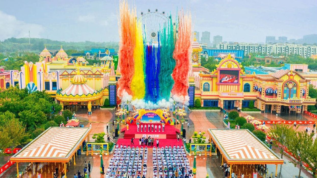 Colorful fireworks display above Boonie Bears theme park with cheering crowd below.