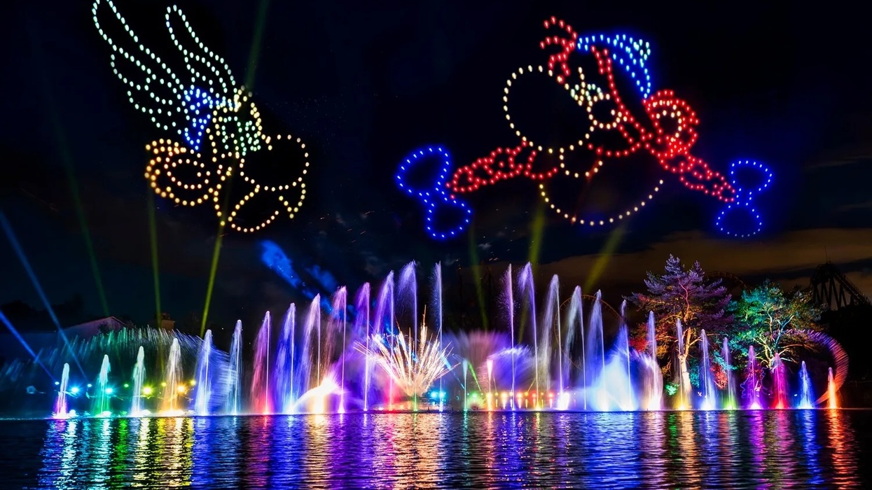 Colorful fountains and drone light show depicting animated characters at night at Parc Asterix