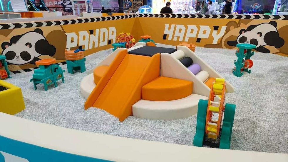 Colorful indoor play area with slides, panda graphics, and soft climbing structures.