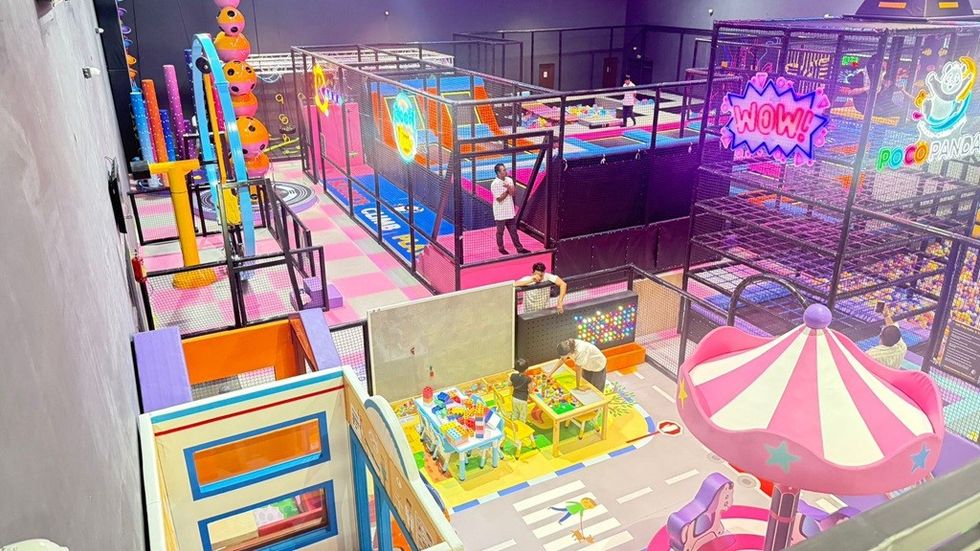 Colorful indoor playground with slides, ball pits, and play structures for children.
