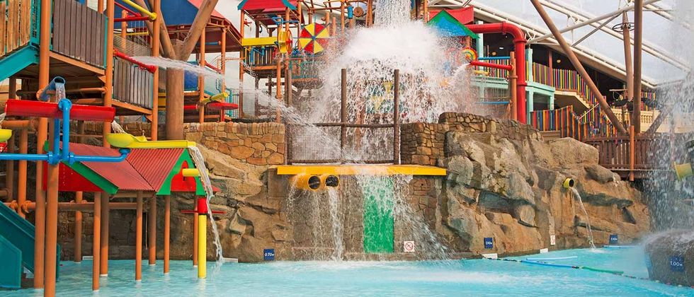 Colorful indoor water park with slides, waterfalls, and climbing structures, Alton Towers