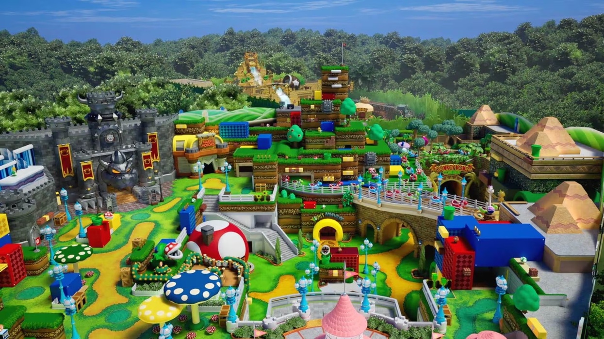 Colorful, intricate theme park called Super Nintendo World with castles, greenery, and various structures resembling a video game.