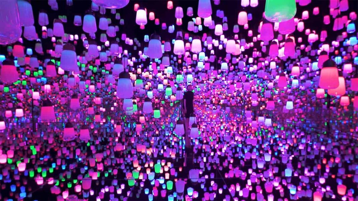 Colorful lanterns in a mirrored room at teamLab create an infinite glowing effect.