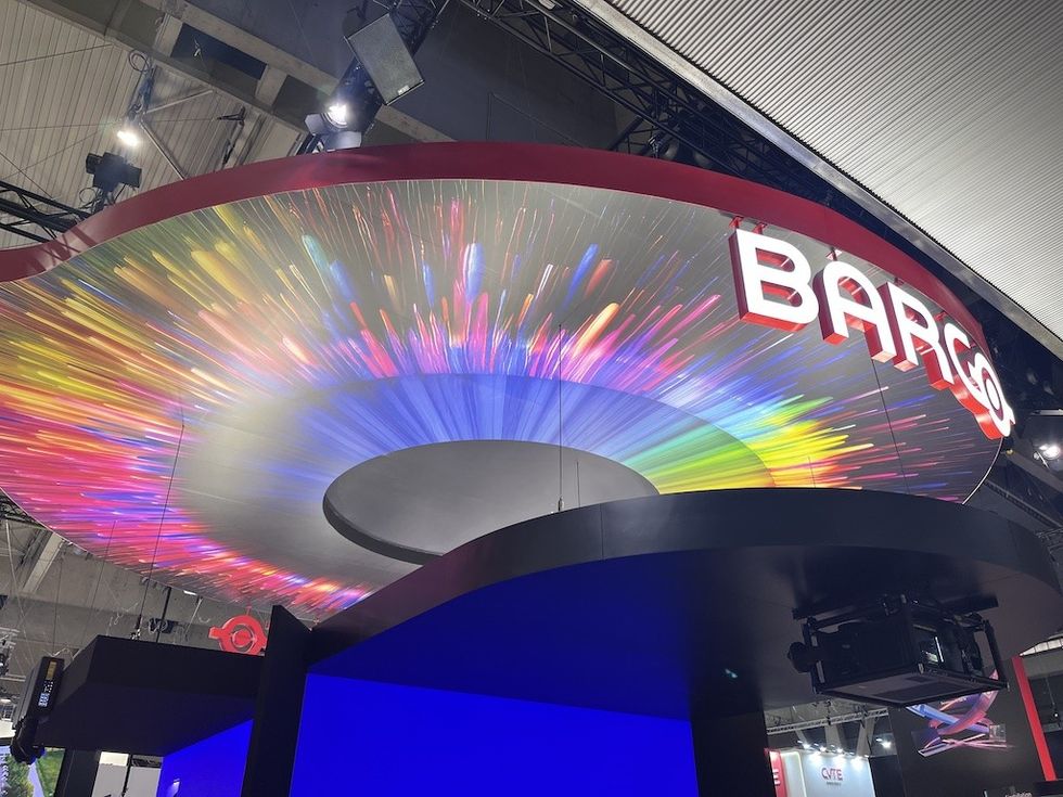 Colorful light display at a trade show booth with Barco logo overhead.