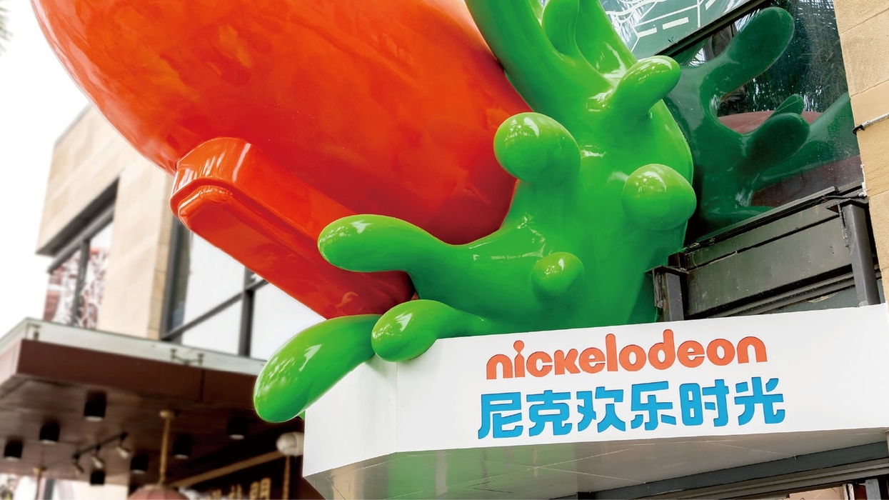Colorful Nickelodeon sign with orange and green splatter design on building exterior.