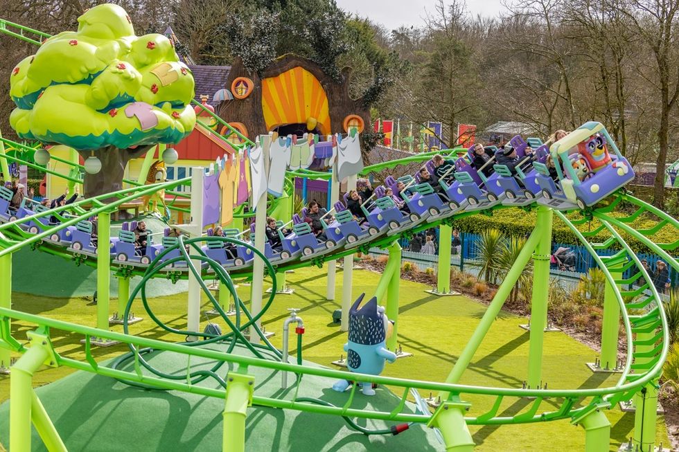 Colorful outdoor roller coaster with cartoon theme and vibrant scenery.
