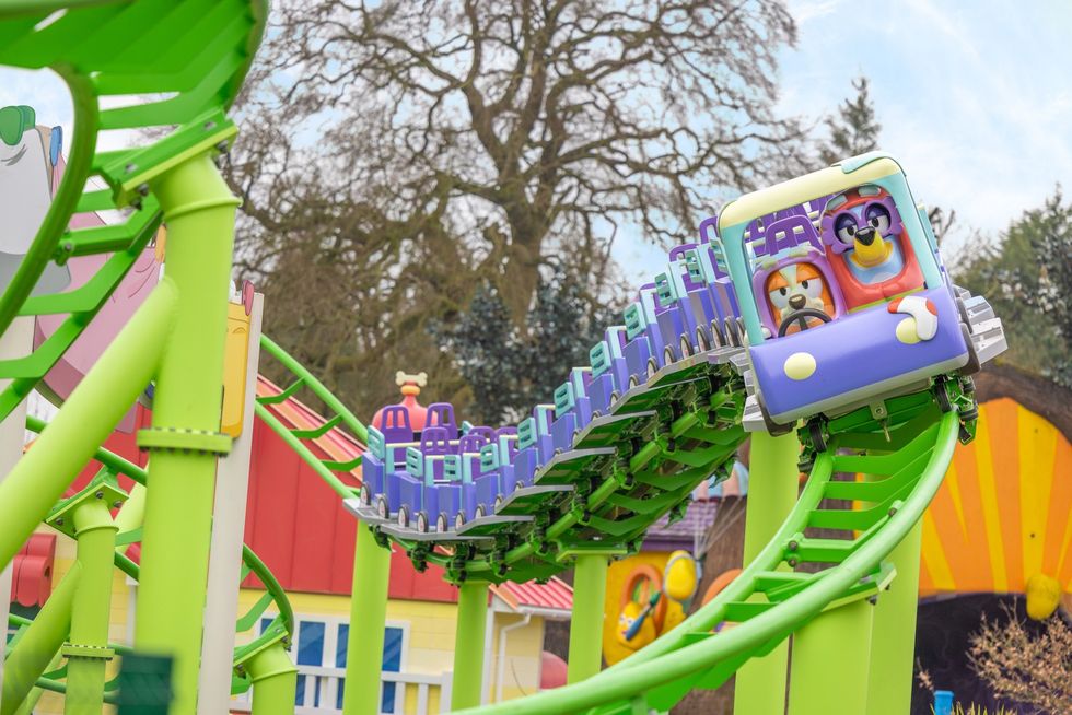 Colorful roller coaster with Bluey characters on a green track.