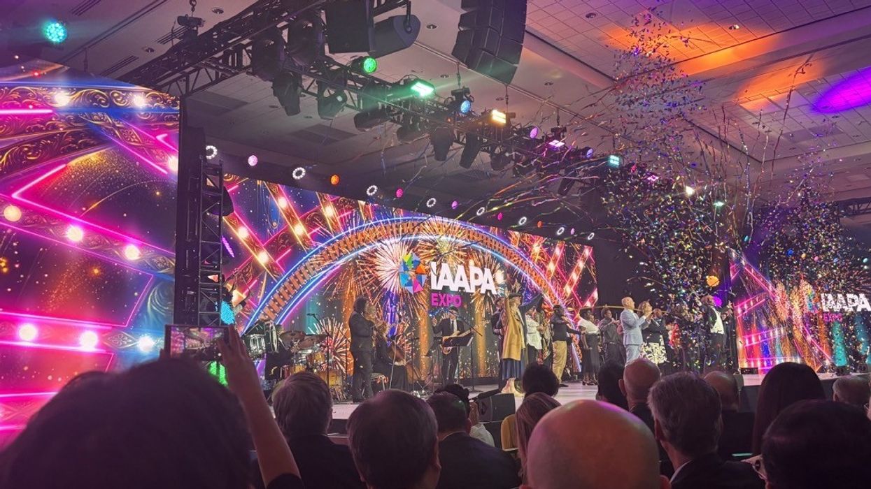 Colorful stage with confetti at IAAPA Expo event, featuring vibrant lights and fireworks.