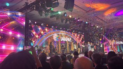 Colorful stage with confetti at IAAPA Expo event, featuring vibrant lights and fireworks.
