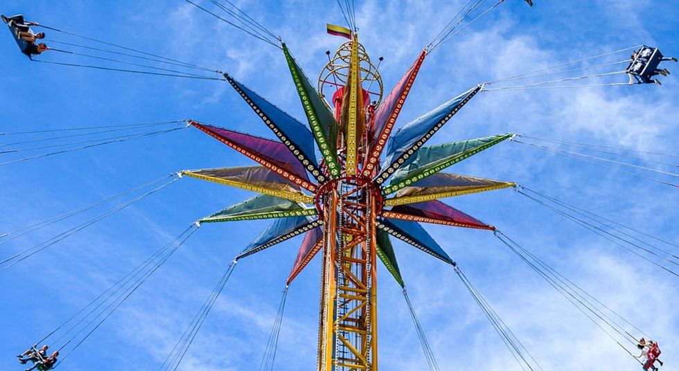 Colorful star-shaped swing ride against a blue sky at Mundo Aventura