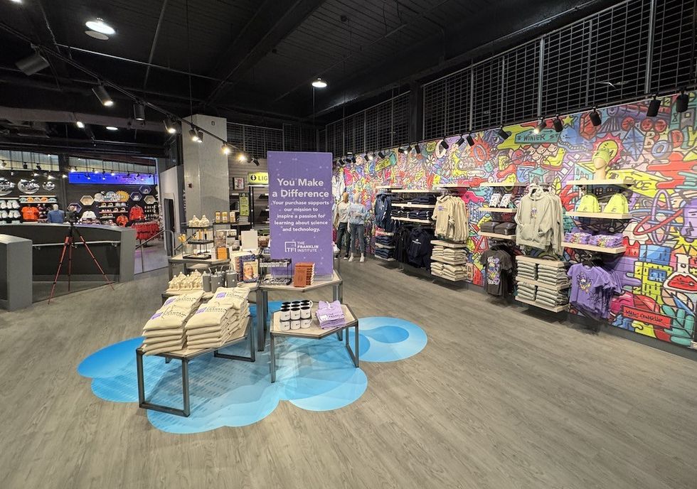 Colorful store interior with clothes, merchandise, and a vibrant graffiti wall mural.