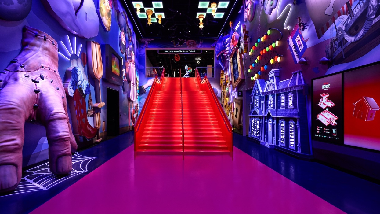 Colorful, surreal hallway with vibrant red stairs and eclectic wall art.