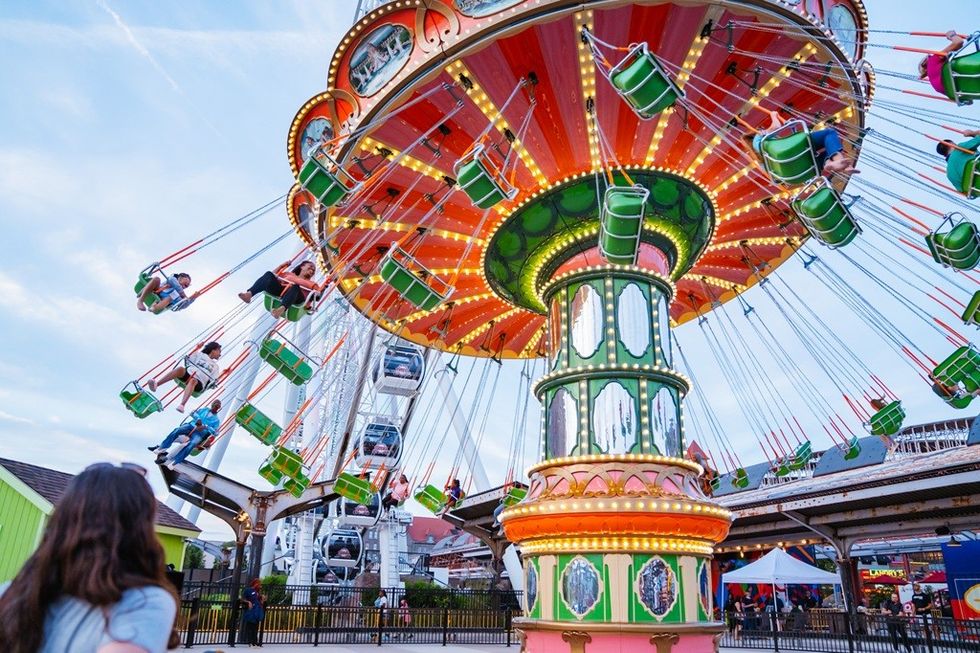 Colorful swing ride at a fairground, with people enjoying the ride.
