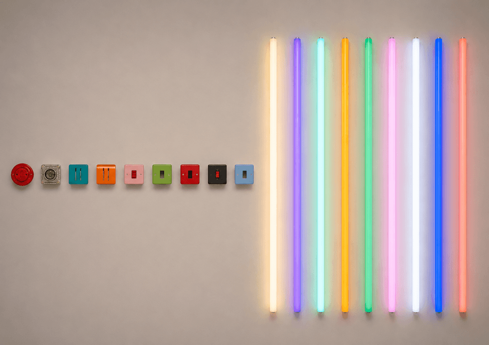 Colorful switches and glowing neon tubes in a row on a wall.