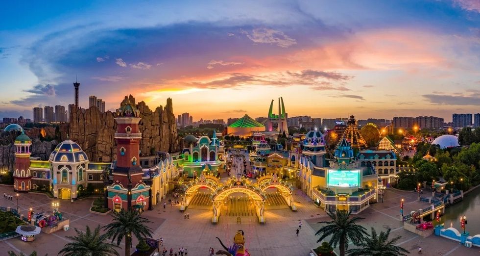Colorful theme park at sunset with vibrant buildings and a dramatic sky at China Dinosaur Park