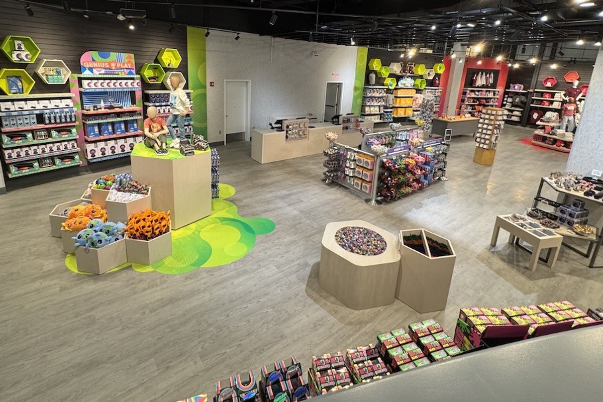 Colorful toy store interior with displays of plush toys and games on wooden shelves.