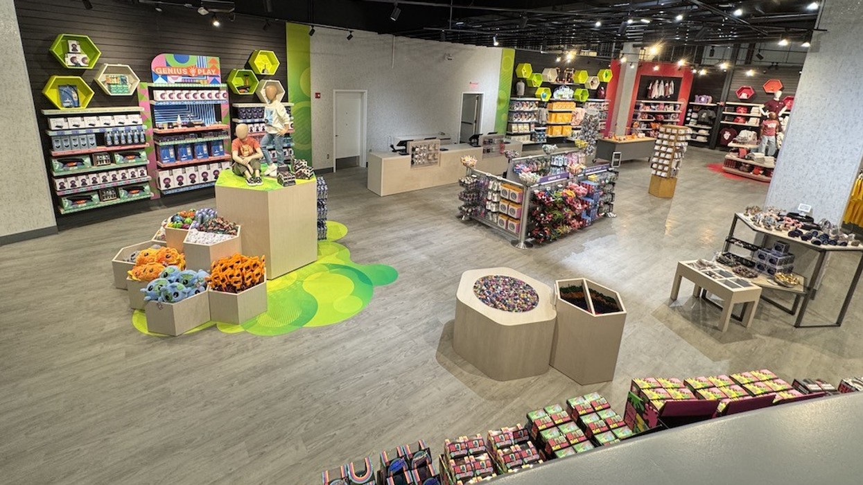 Colorful toy store interior with displays of plush toys and games on wooden shelves.