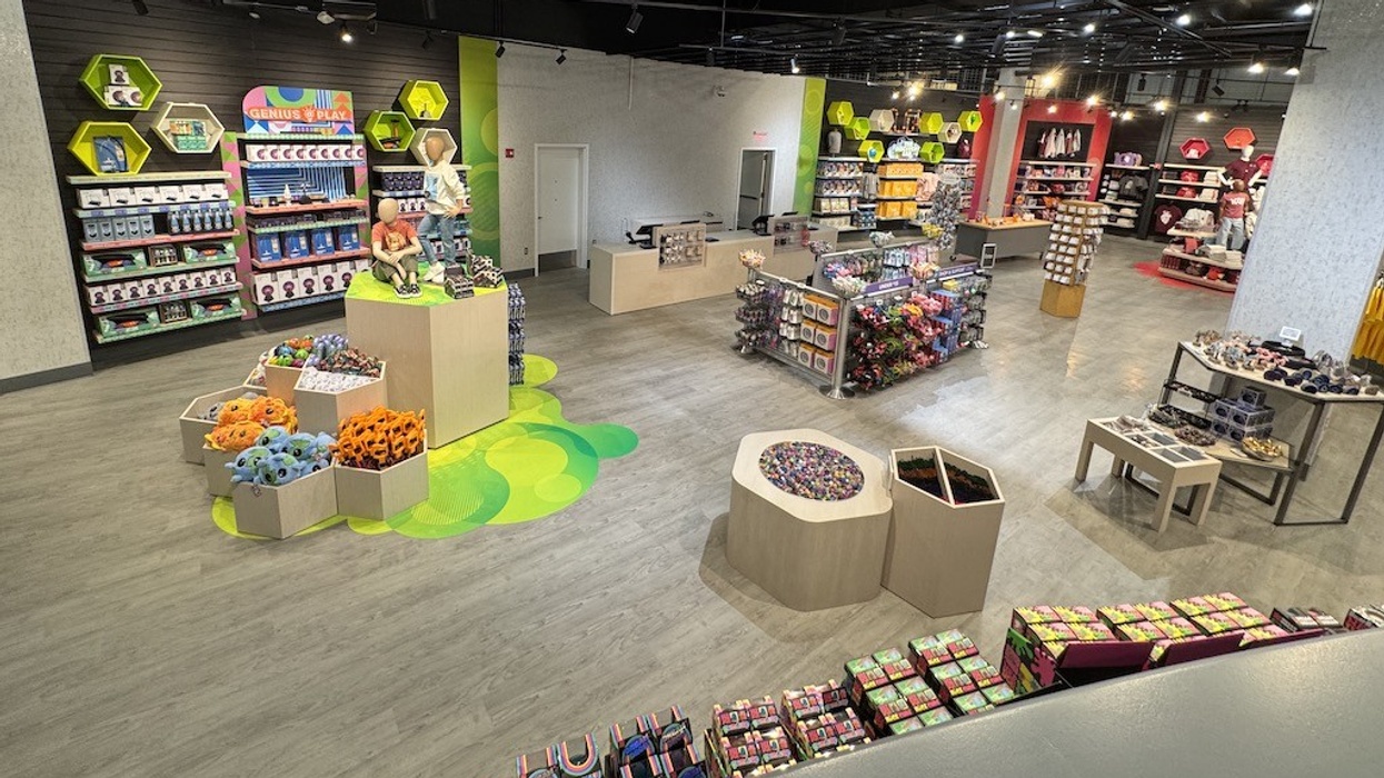 Colorful toy store interior with displays of plush toys and games on wooden shelves.