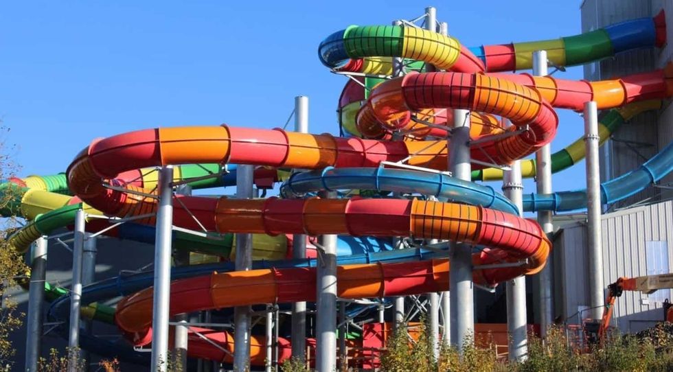 Colorful, twisting water slides with multiple loops and turns under a clear blue sky, Waterworld, Stoke-on-Trent