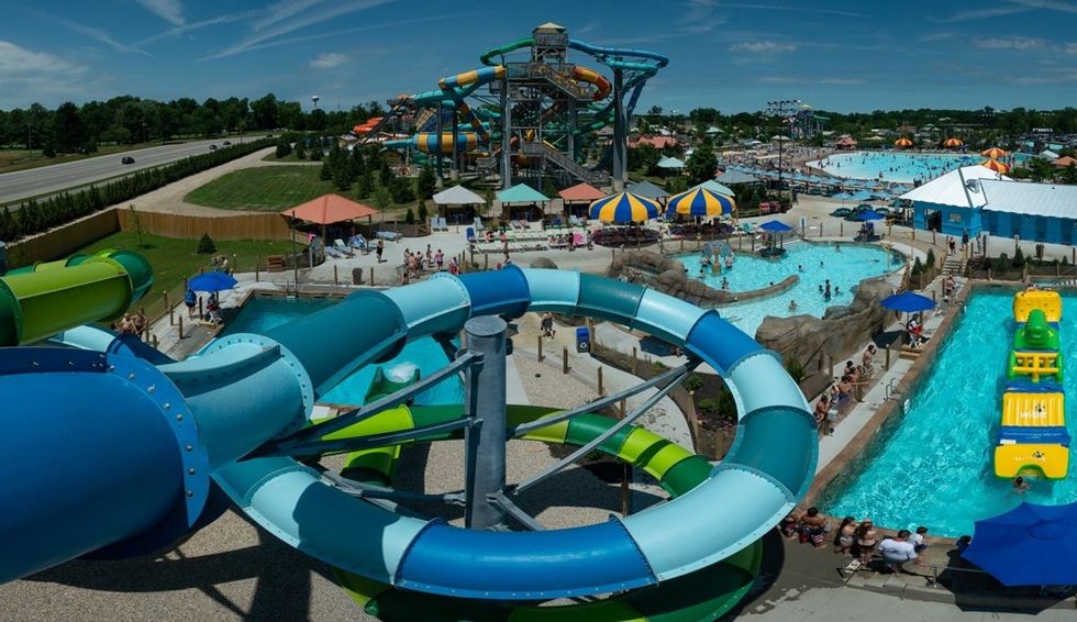 Colorful water park called Zoombezi Bay with slides, pools, and people enjoying a sunny day.