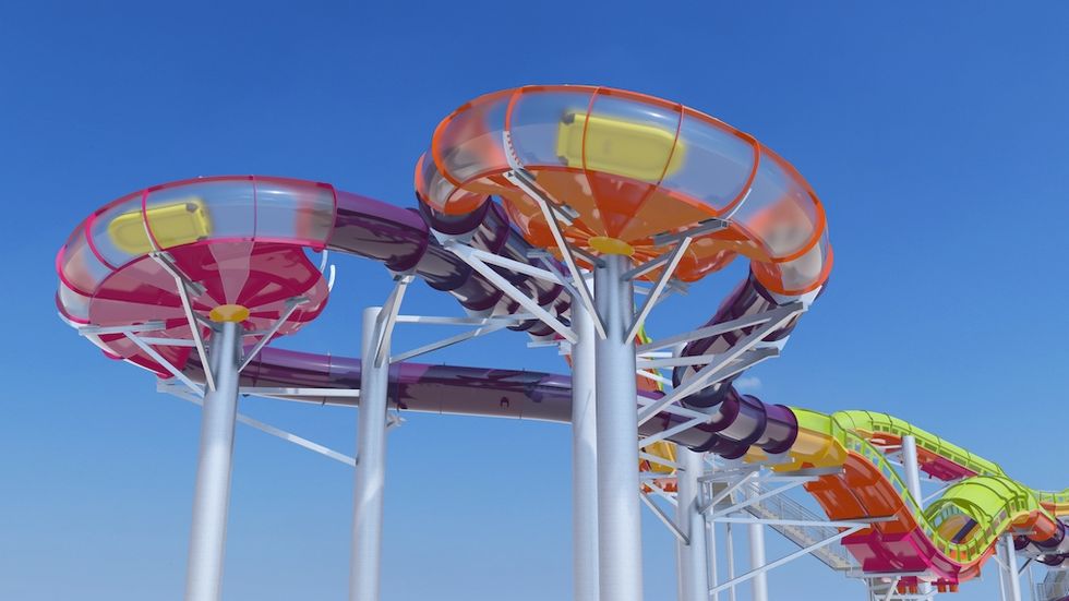 Colorful water slide with clear, tube-like sections and blue sky background.