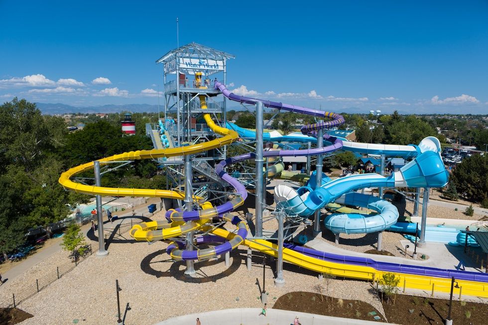 Colorful water slides at a water park under a clear blue sky.