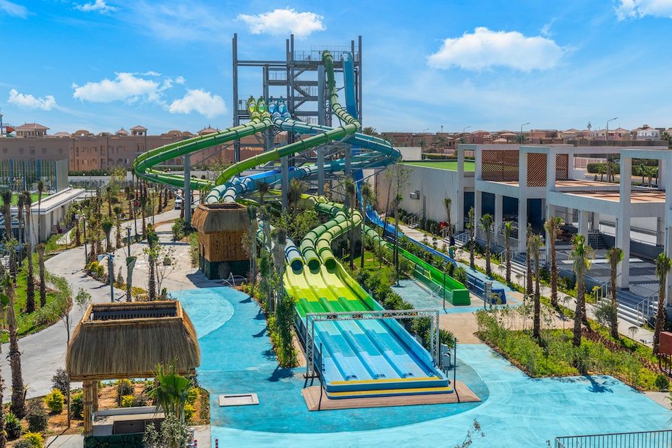 Colorful water slides in a vibrant outdoor water park under a clear blue sky.