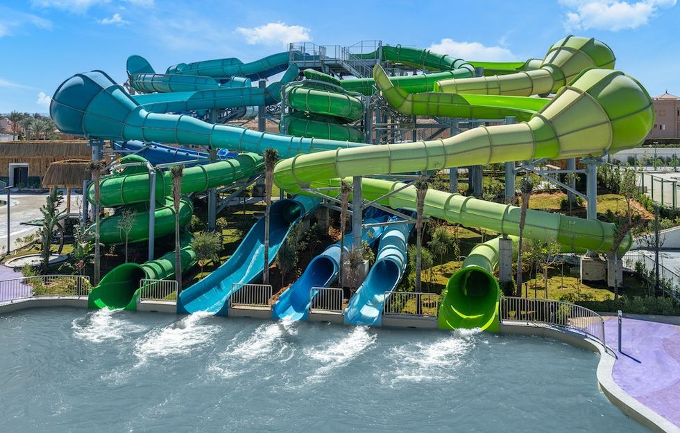 Colorful water slides twisting above a large pool at a water park.