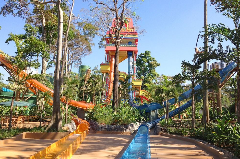 Colorful water slides winding through a lush, tropical water park called Xocomil