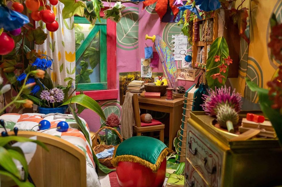 Colorful, whimsical room filled with vibrant plants, books, and eclectic decor.