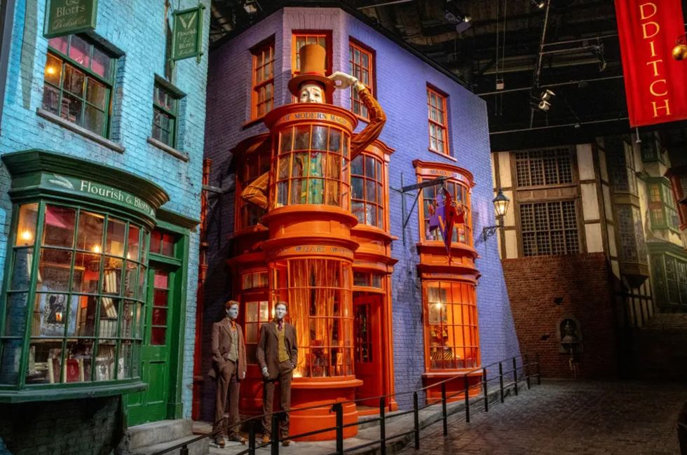 Colorful, whimsical shop facades in a magical alley setting, with mannequins outside at Warner Bros. Studio Tour Tokyo
