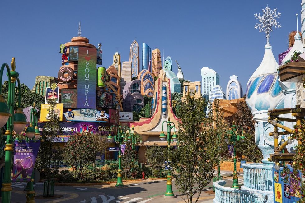 Colorful, whimsical Zootopia cityscape with modern buildings and playful signage under clear blue sky at Shanghai Disney
