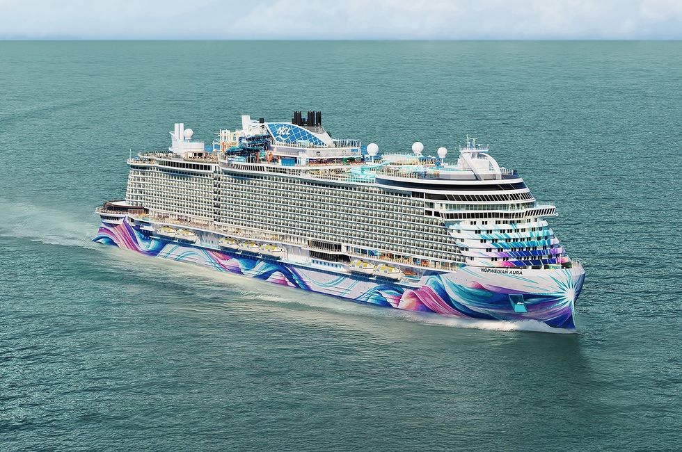 Colorfully painted cruise ship called Norwegian Aura sailing in open water.