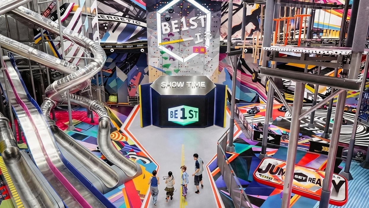Colourful indoor BE1ST adventure park with multi-level slides and climbing structures.