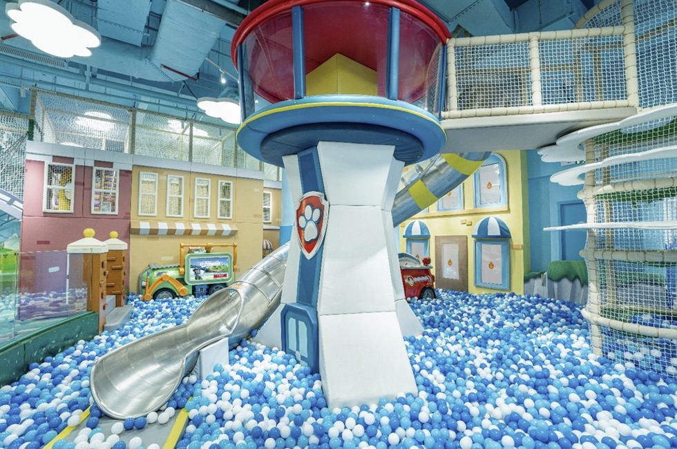 Colourful indoor children's play area at Nickelodeon Playtime 2.0, with a ball pit, slide, and firefighter-themed climbing structure.