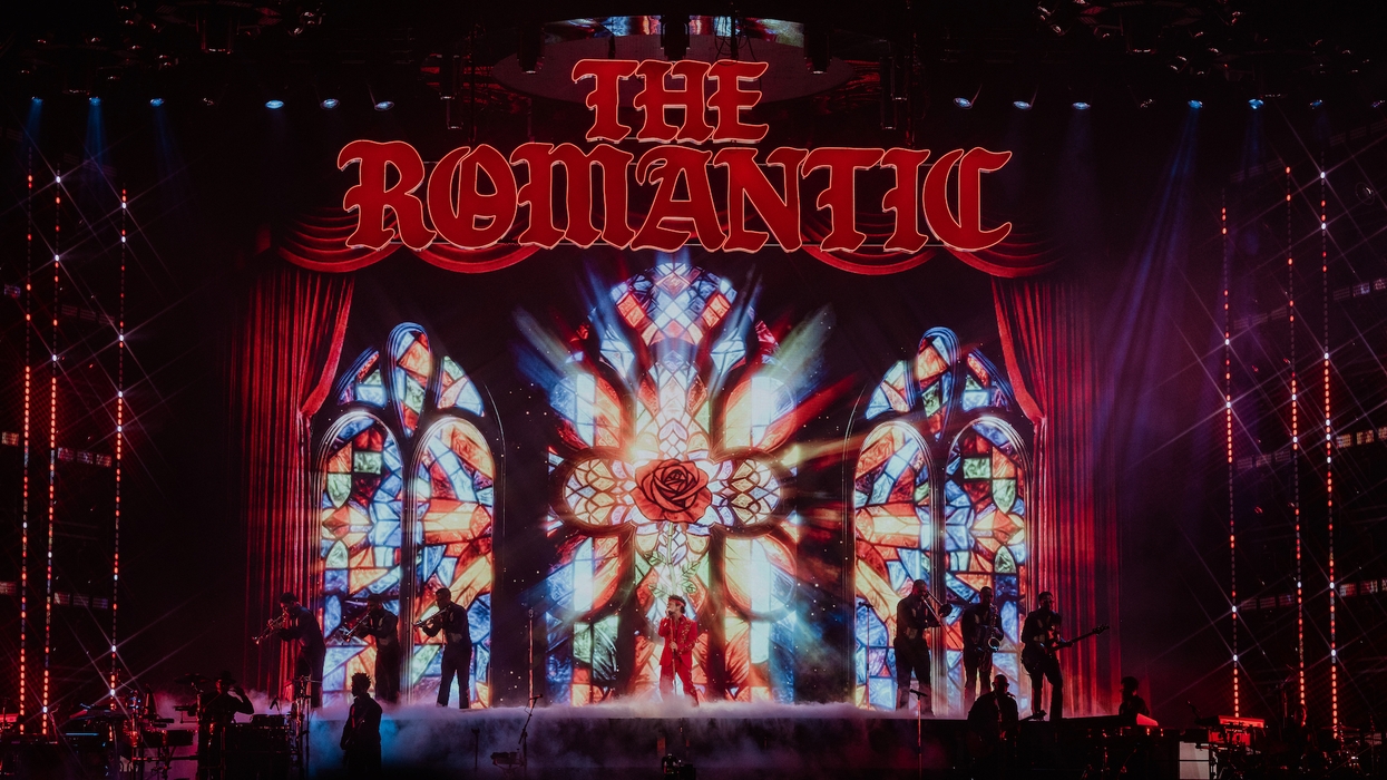 Concert stage with band, stained glass backdrop, and "The Romantic" in red letters.