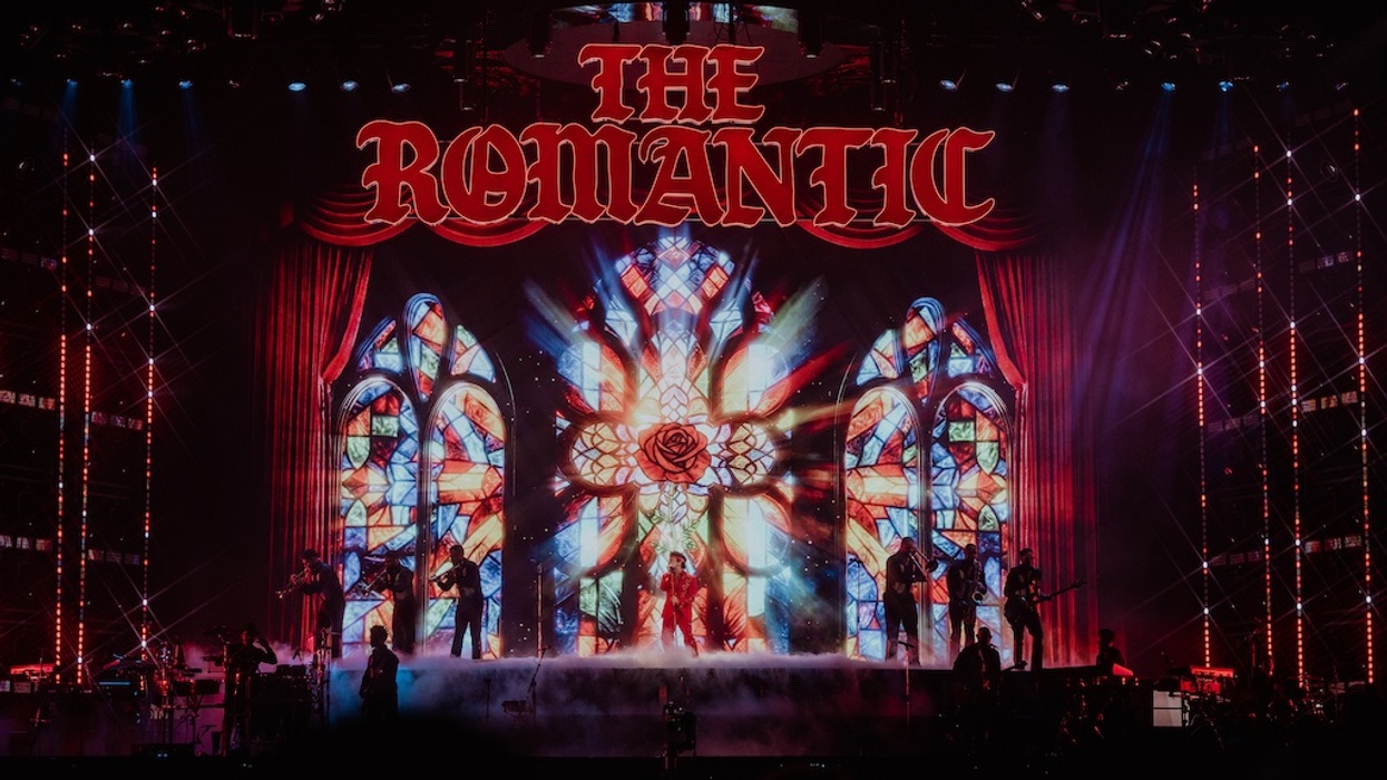 Concert stage with "The Romantic" above stained glass backdrop and performers.
