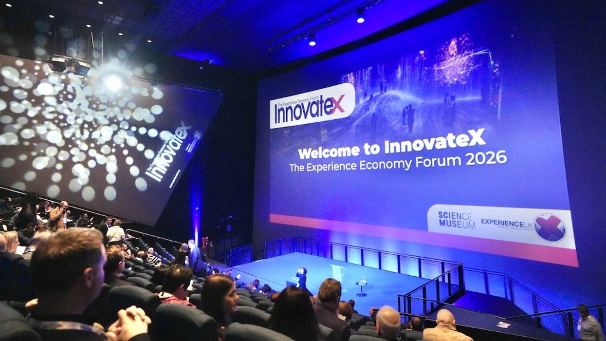 Conference audience facing large stage screen reading "Welcome to InnovateX Forum 2026".