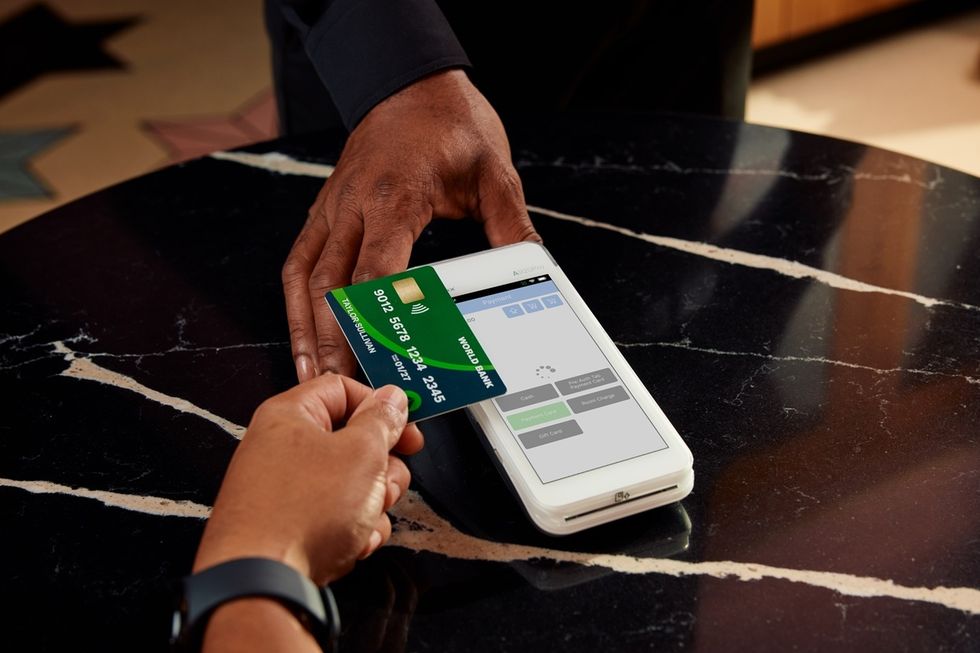 Contactless payment with a card on a black marble table.