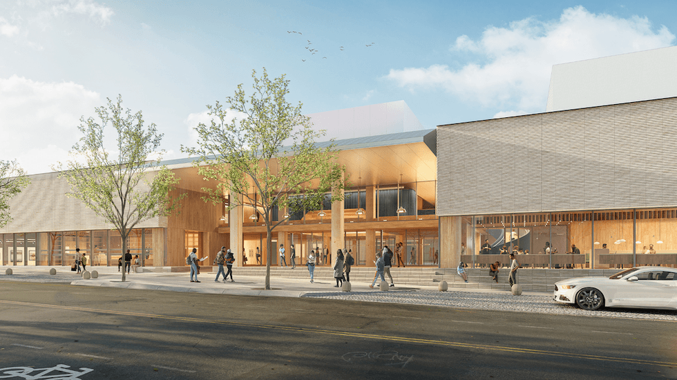 Contemporary building with glass facade, trees, and pedestrians on a sunny day.
