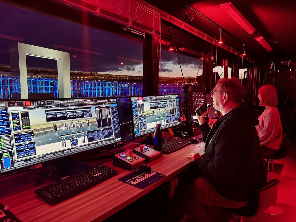 Control room overseeing a lit water show with screens displaying software controls