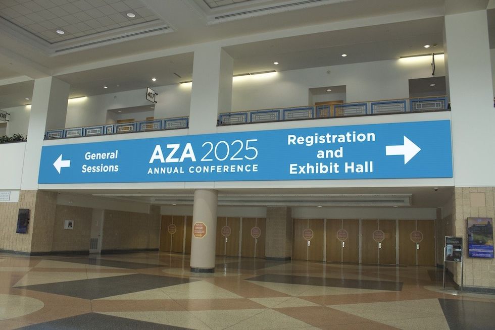 "Convention center interior with signs for AZA 2025 conference sessions and exhibit hall."