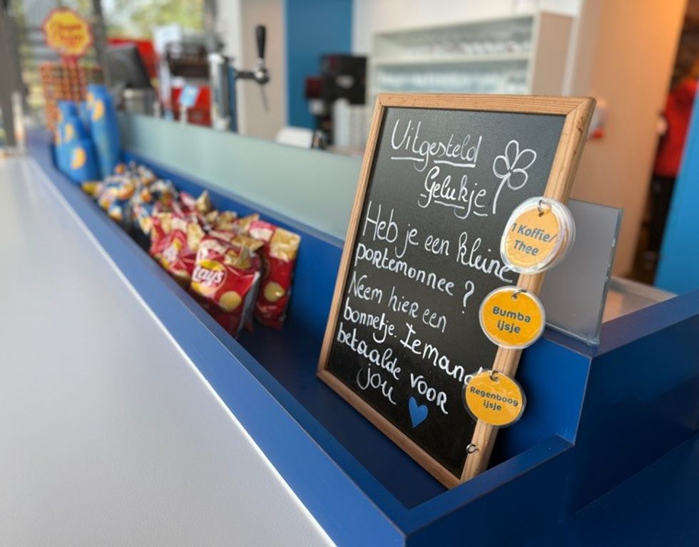 Counter with snacks and a Dutch sign offering free treats for those in need.